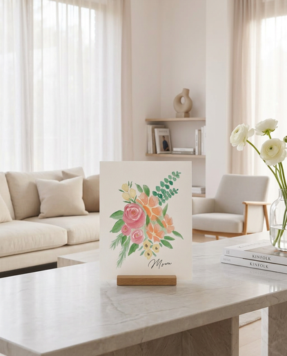 Barely Blush personalized watercolor fingerprint art print on oak gallery stand in living room