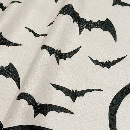 Close up detail of Bat Bash Halloween tea towel showing inky black bats in flight on cream background, 723 & Co. Design Studio
