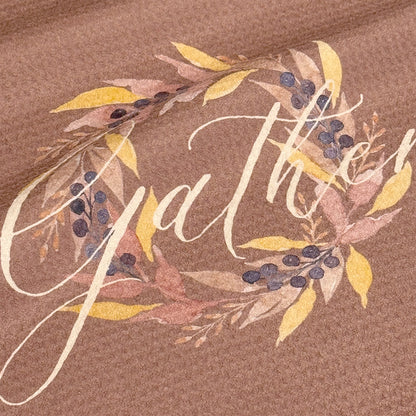 Close up detail of Gather watercolor tea towel showing gold leaves, mauve botanicals, and deep navy berries around cream Gather script — 723 & Co. Design Studio