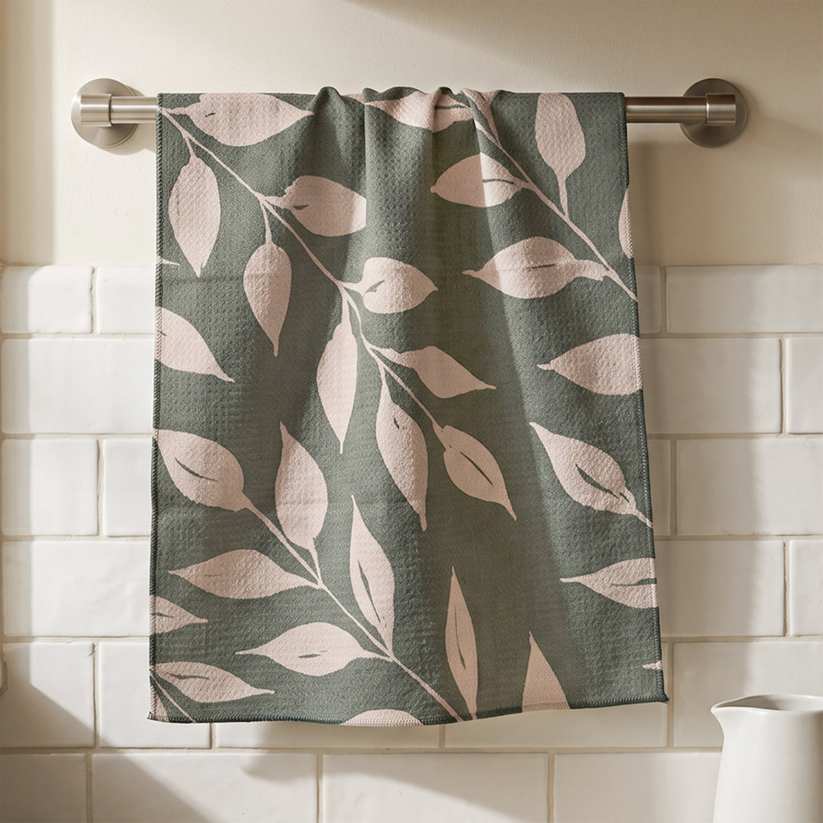 Sage Wild Leaves watercolor botanical tea towel hanging in kitchen setting with natural wood and white tile, 723 & Co. Design Studio